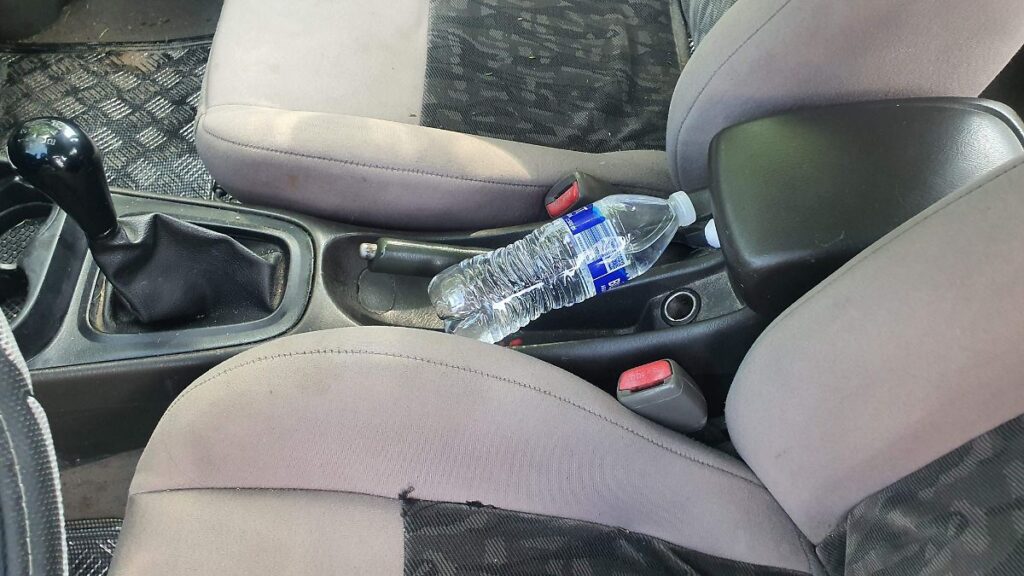 Botella de agua de plástico expuesta al sol en el interior de un automóvil durante la temporada de calor