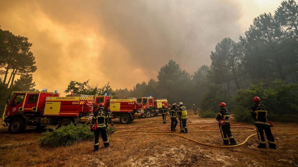 Emergencia en Europa por incendios forestales en España y Francia Bomberos combatiendo incendio forestal con llamas y humo en bosque mediterráneo de España