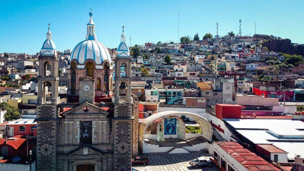 Feria tradicional en Hidalgo con juegos mecánicos, puestos de antojitos mexicanos y familias disfrutando de las festividades patronales